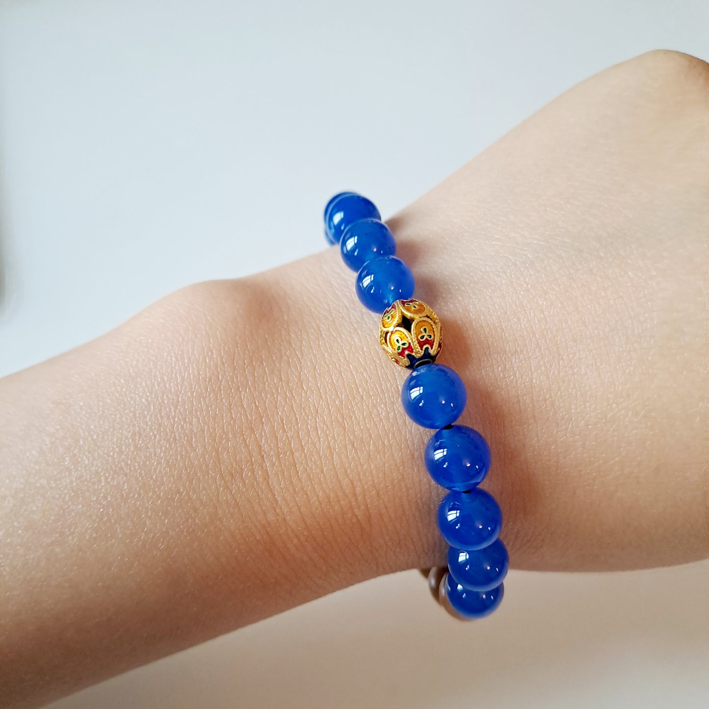 Natural sandalwood beads paired with blue agate beads and Tibetan silver fortune beads bring good luck and assist in meditation