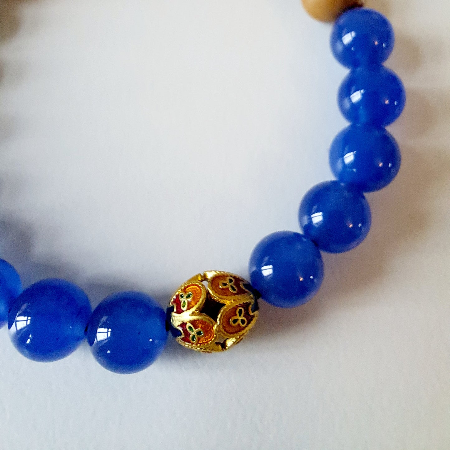 Natural sandalwood beads paired with blue agate beads and Tibetan silver fortune beads bring good luck and assist in meditation