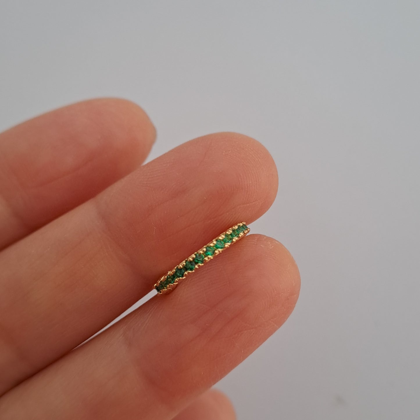 Elegante vergoldete Ohrklemme mit funkelndem grünen Zirkonia