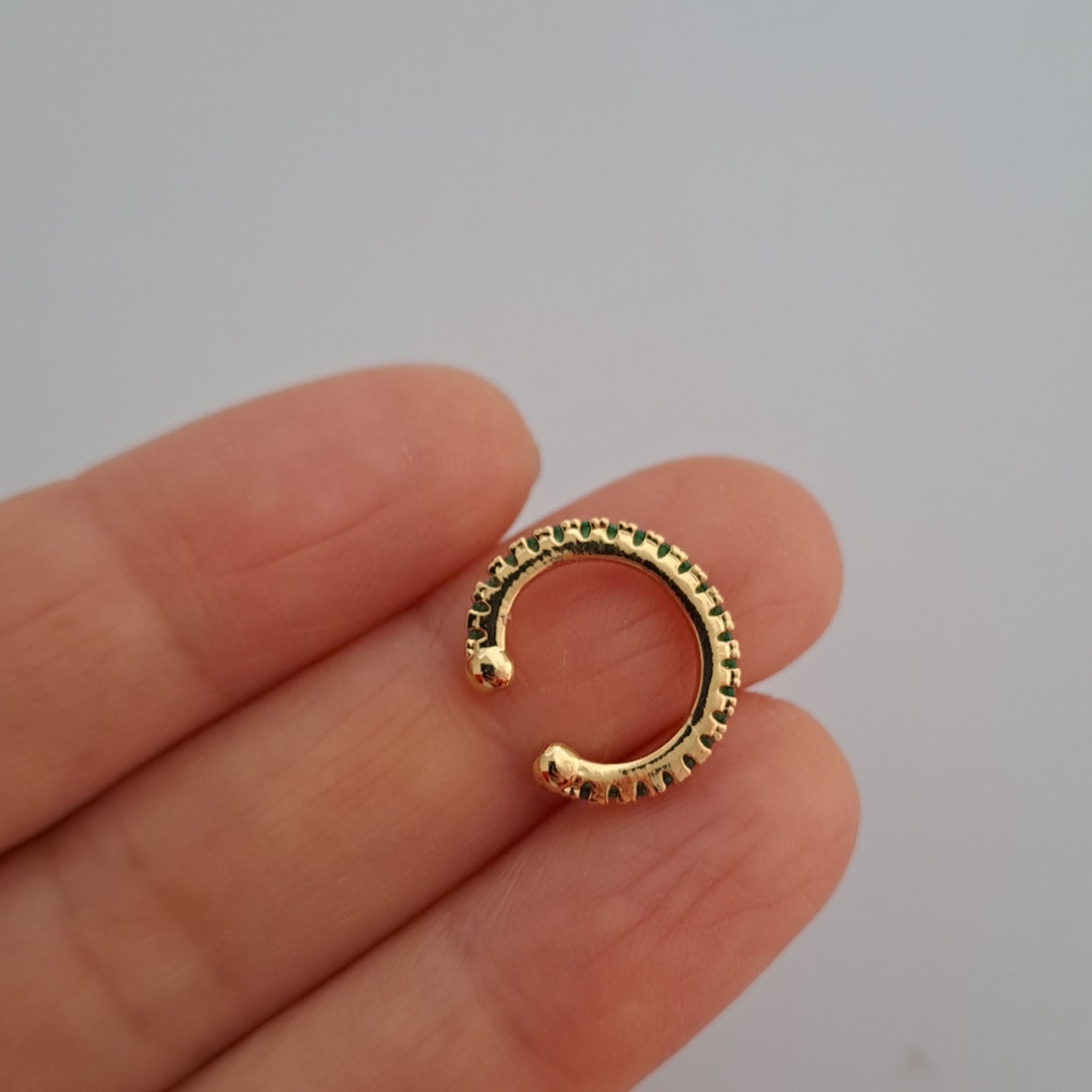 Elegante vergoldete Ohrklemme mit funkelndem grünen Zirkonia