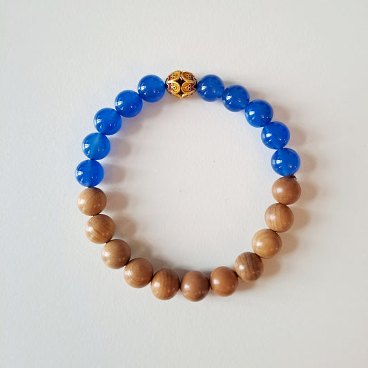 Natural sandalwood beads paired with blue agate beads and Tibetan silver fortune beads bring good luck and assist in meditation